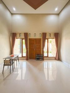 uma sala de jantar com uma mesa e algumas janelas em Room 1 at Villa Restu 5, King Room, Private Bath em Paragajen