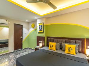 a bedroom with a large bed with yellow pillows at The Hosteller Rishikesh, Ganges in Rishīkesh
