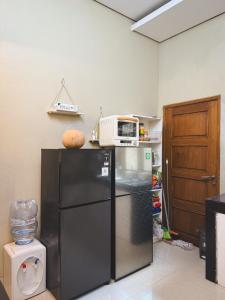 uma cozinha com um micro-ondas em cima de uma geladeira em Room 1 at Villa Restu 5, King Room, Private Bath em Paragajen mais 18 fotografias