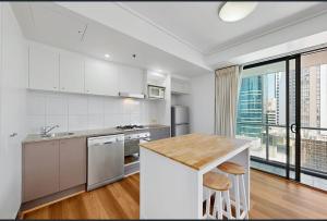 a kitchen with white appliances and a large window at Centre CBD - Pool Spa Gym - Water View - Sleep 4 in Brisbane +6 photos