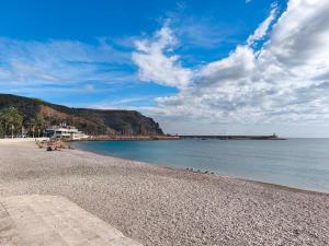 een strand met een rotsachtige kustlijn en de oceaan bij Estancia Mar y Montaña in Jávea