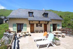 a house with a patio with chairs and a building at Le cailhabas in Lescun