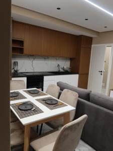 a kitchen with a table and chairs in a kitchen at Marbel Apartments in Shëngjin