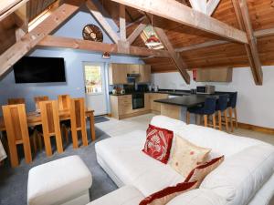 a living room with a white couch and a kitchen at Pendre Barn in Llanfyrnach