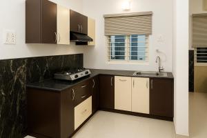 a kitchen with brown cabinets and a sink at Spiritual Apartment in Vrindāvan