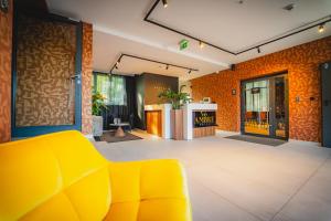 a lobby with a yellow couch in a room at Ambre Hotel in Rzeszów