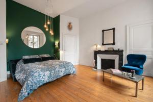 une chambre avec un lit, une chaise et un miroir dans l'établissement T3 Havre de paix 6p - 115m Cœur Saint Sernin Toulouse - PKG 3 min, à Toulouse 21 autres photos