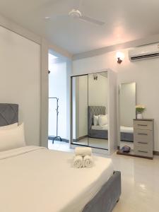 a bedroom with a bed with two towels on it at Dhoani Maldives Boutique in Kendhoo