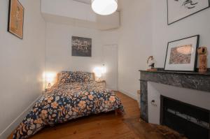 une chambre avec un lit et une cheminée dans l'établissement T3 Havre de paix 6p - 115m Cœur Saint Sernin Toulouse - PKG 3 min, à Toulouse