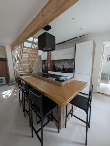 a kitchen with a wooden counter top and black chairs at Maison des Artistes Paris Giverny in Vernon