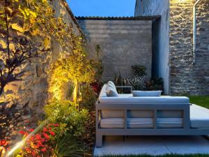a patio with a bench and flowers in a garden at Jardin Secret - Maison 80 m2, jardin privé & parking, début Route des Vins in Marlenheim