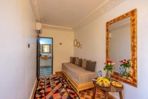 a living room with a couch and a mirror at Riad des remparts Marrakech in Marrakech