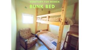 a bunk bed and a chair in a room at Nemurupa Garden Hostel & Yoga in Narita