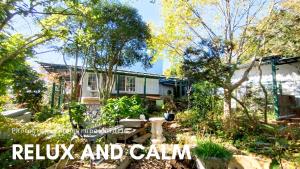 a garden in front of a house with the words relax and earn at Nemurupa Garden Hostel & Yoga in Narita