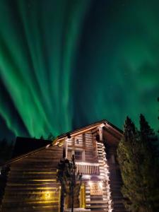 an old house with the aurora in the sky at Villa Aatu Levi Ski-in Ski-out in Levi