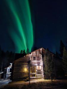 an old house with the aurora in the sky at Villa Aatu Levi Ski-in Ski-out in Levi