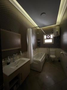 a bathroom with a tub and a sink and a toilet at Garden View apartment in Madīnat aţ Ţalāʼi‘ +6 photos