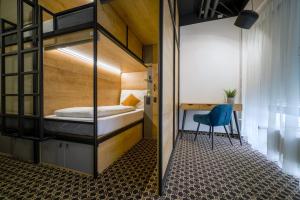 een kamer met een stapelbed, een bureau en een stoel bij CHORS like a hotel - Capsule & NFT Boutique Hostel Bratislava - City Center in Bratislava
