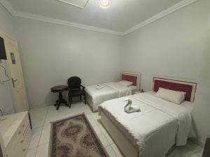 una habitación con 2 camas y un cisne en la cama en Falcon pyramids inn, en El Cairo