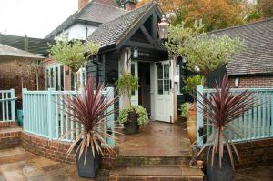 a house with a blue fence and two potted plants at The Cowdray Arms in Worth