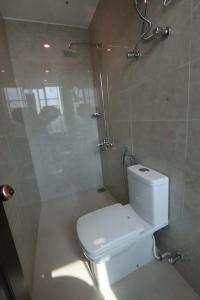 a bathroom with a white toilet and a shower at Shelton's Rezidor Peshawar in Peshawar