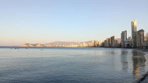 a large body of water with a city and buildings at Apartamento familiar primera línea de playa in Benidorm