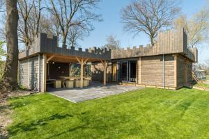 a modern house with a large backyard at Kampeerdorp de Zandstuve - Kindvriendelijke Vakantiepark in Rheeze +10 photos