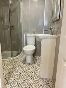 a bathroom with a toilet and a sink and a shower at Stylish & Spacious 2 Storey, 3 Bed Apartment in Kent +15 photos