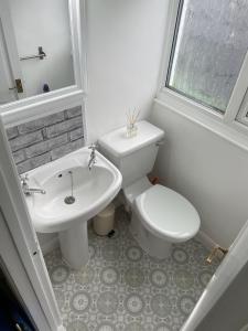 a white bathroom with a toilet and a sink at Stylish & Spacious 2 Storey, 3 Bed Apartment in Kent +15 photos