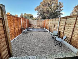 a patio with chairs and tables and a fence at Stylish & Spacious 2 Storey, 3 Bed Apartment in Kent