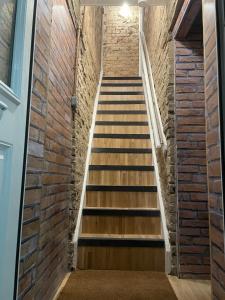 a staircase leading up to a brick wall at Stylish & Spacious 2 Storey, 3 Bed Apartment in Kent