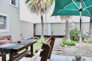 スワコプムントにあるBeach View Retreatの木製テーブルと傘付きのパティオ