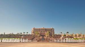 a large building with palm trees and a fountain at Emirates Palace Mandarin Oriental, Abu Dhabi in Abu Dhabi