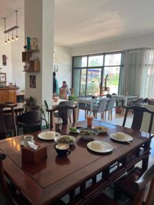 a wooden table with plates of food on top of it at KL's Coffee & Hostel in Pakse