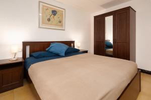 a bedroom with a large bed with blue pillows at Poble tranquil prop de Tarragona i Portaventura in Catllar