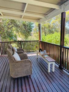 - une terrasse couverte avec 2 chaises et une table basse dans l'établissement Addo Good Hope Guest House, à Sunland
