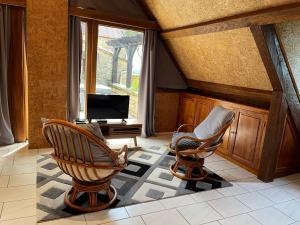 a living room with two chairs and a television at La Closerie de Baneuil in Baneuil