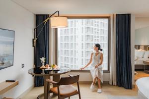 a woman in a hotel room looking out the window at Montien Hotel Surawong Bangkok in Bangkok +136 photos
