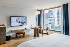 une chambre d'hôtel avec un lit et une grande fenêtre dans l'établissement Montien Hotel Surawong Bangkok, à Bangkok