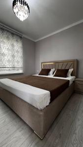 ein Schlafzimmer mit einem großen Bett und einem Kronleuchter in der Unterkunft Comfort Point Hotel in Bischkek