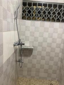a shower in a bathroom with a tile wall at Two Bedrooms Standby Generator DSTV Netflix W-iFi in Takoradi