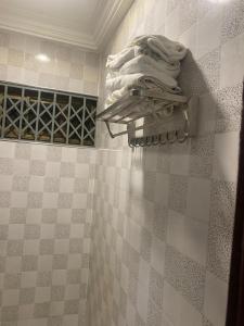 a pile of towels on a shelf in a bathroom at Two Bedrooms Standby Generator DSTV Netflix W-iFi in Takoradi +10 photos