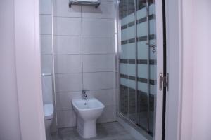 a bathroom with a toilet and a glass shower at Apartamento Orange Triana centro in Seville