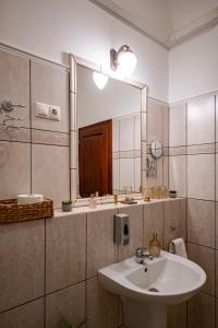 a bathroom with a sink and a mirror at Mádi Kúria Hotel és Rendezvényközpont in Mád