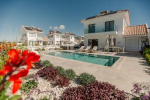 a villa with a swimming pool and a house at Nadine sea side villas in Larnaca