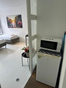 a kitchen with a microwave on top of a refrigerator at Amsliving in Amsterdam