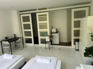 a room with two beds and a table and a desk at Amsliving in Amsterdam +1 photo