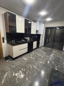 a kitchen with white cabinets and a marble floor at Elite garden in Marrakech