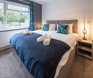 a bedroom with a large bed with towels on it at Kinsale House by Cliftonvalley Apartments in Brislington