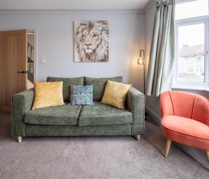 a living room with a green couch and a lion painting at Kinsale House by Cliftonvalley Apartments in Brislington